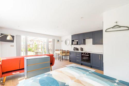 切斯特Charming Chester Studio with private garden & free parking的厨房配有蓝色橱柜和橙色沙发