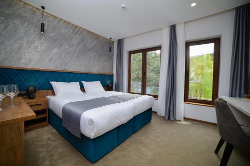 兹拉蒂博尔Lakeside的一间卧室配有一张大床、一张书桌和窗户。