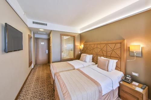 伊斯坦布尔Ramada By Wyndham İstanbul Taksim的酒店客房设有两张床和一台平面电视。
