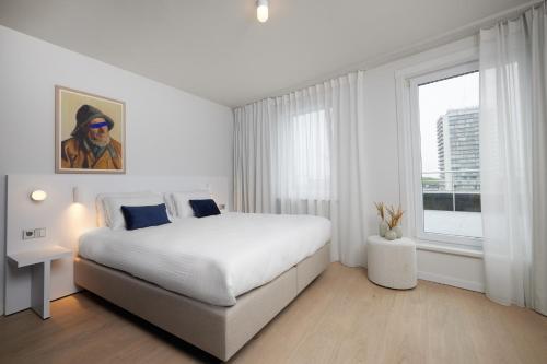 奥斯坦德伯灵顿C-酒店 的白色的卧室设有一张大床和一个窗户