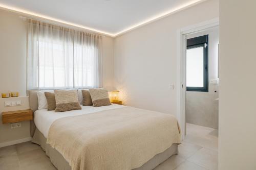 马贝拉Casa Las Palmeras的白色的卧室设有一张大床和一个窗户