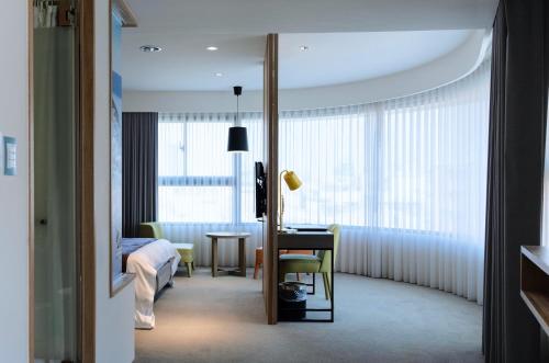 台中市富盛商旅的酒店客房设有床、桌子和窗户。
