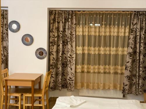 布达佩斯埃斯普利特酒店的配有桌子和窗帘的房间