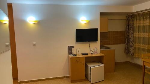 布达佩斯埃斯普利特酒店的客房设有一张桌子,墙上配有电视。