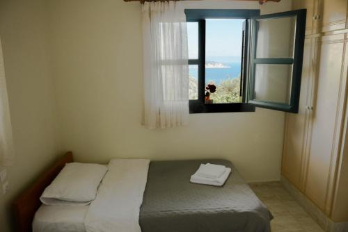 AnomeriáPerfetto Country House - Myrtos View的一间卧室设有一张床和一个美景窗户。