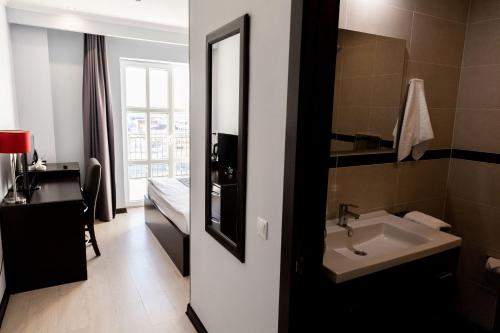 阿克套Chagala Aktau Hotel的一间带水槽和镜子的浴室