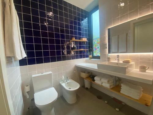 拉戈阿CaLoura 76的蓝色瓷砖浴室设有卫生间和水槽