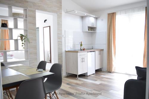 苏托莫雷Apartmani "Nebo"的厨房配有白色橱柜和桌椅