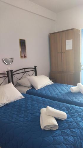 基莫洛斯岛Elzahed apartments bonaccia的一间卧室配有两张带毛巾的床