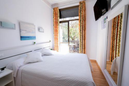巴塞罗那拉莫斯旅馆的卧室配有白色的床和窗户。