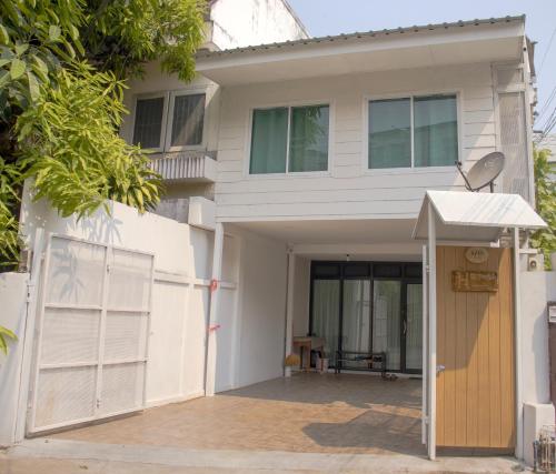 清迈Home Story Hostel Chiang Mai的白色的房子,有门和门
