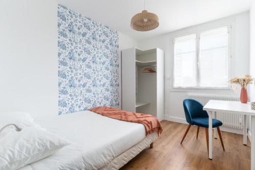 南特Joli Appartement avec Garage sur l'Île de Nantes的一间卧室配有一张床、一张桌子和一把椅子