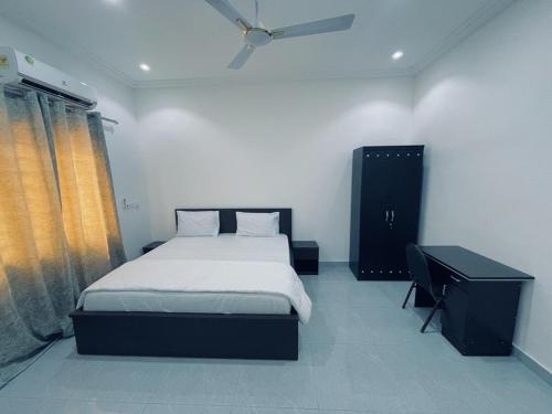 AdentanRakka Guest House的一间卧室配有一张床、一张书桌和一个窗户。