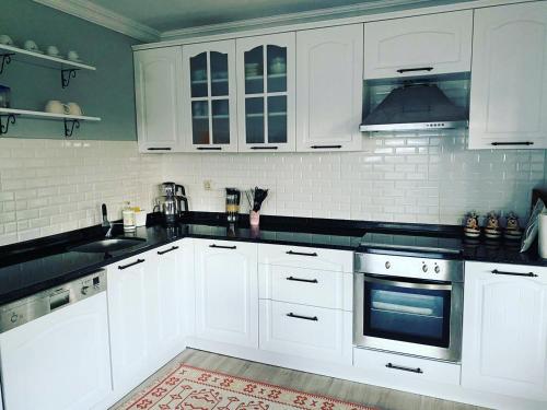 阿克恰阿巴德Trabzon saklı villa的厨房配有白色橱柜和黑色台面