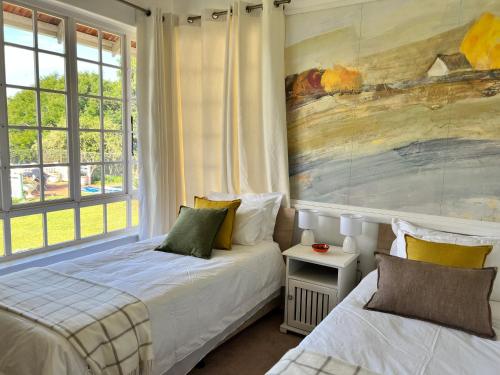 彼得马里茨堡Edgehill的一间卧室设有两张床,墙上挂着一幅画