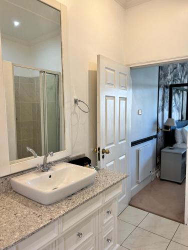 彼得马里茨堡Edgehill的白色的浴室设有水槽和镜子