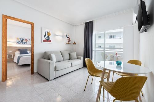 伊维萨镇Hotel Apartamentos Vibra Lux Mar的客厅配有白色的沙发和桌子