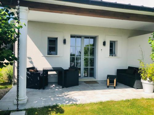 翁弗勒尔Bel Air Studios-Terrasse couverte-Jardinet-Vue Pont de Normandie-Parking privé的房屋前方设有黑家具的庭院