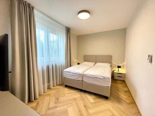 布拉迪斯拉发Villa Bea的一间卧室设有一张床和一个大窗户