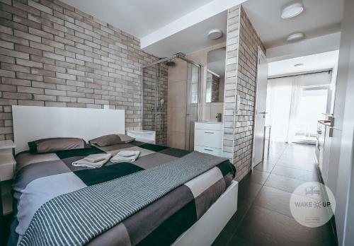 阿尔泽特河畔埃施WakeUp Esch-City的一间卧室设有一张大床和砖墙