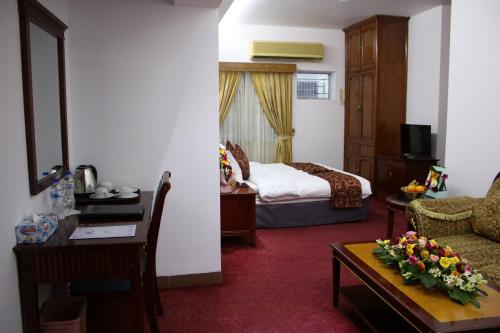 达卡Hotel West Valley Dhaka的酒店客房设有床和客厅。