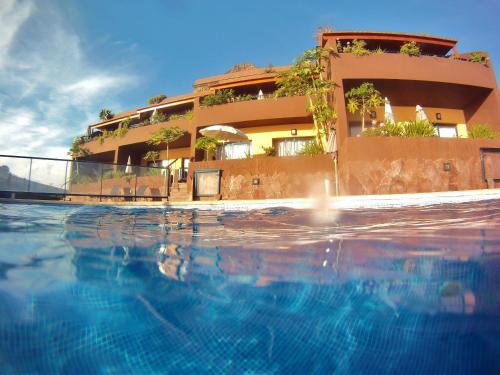 巴耶格兰雷伊Chijere Faro del Inglés的大楼前设有游泳池的酒店