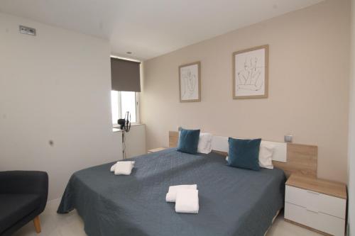 波尔蒂芒Praia_da_Rocha_Vista_Mar/Ocean_View的一间卧室配有蓝色的床和2条毛巾