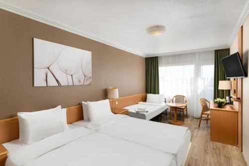 布达佩斯丹比乌斯阿瑞纳酒店的酒店客房设有一张白色大床和一张书桌