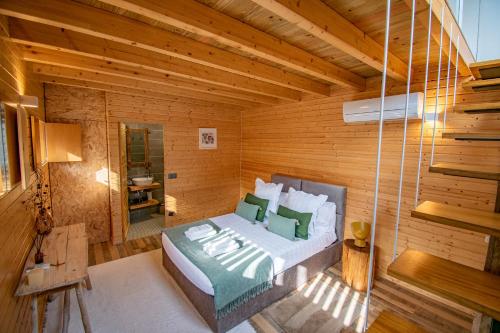 吉马良斯Villa Prendal Eco Living - Minho's Guest的木制客房内的一间卧室,配有一张床