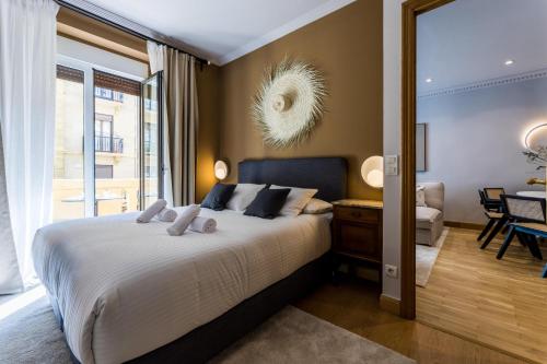 圣塞瓦斯蒂安ONDARRA Suite Apartment的一间卧室设有一张床和一间客厅。
