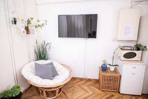 特拉维夫Dizengoff square garden的一间带椅子和墙上电视的房间