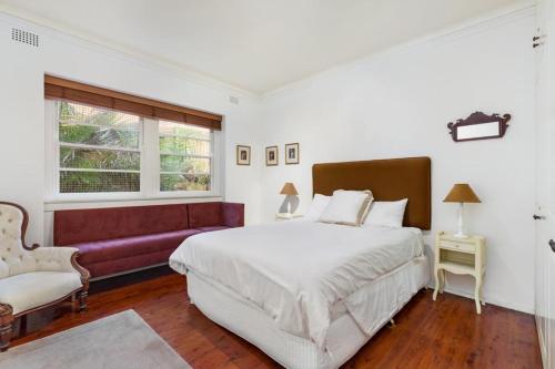 悉尼Double Bay Harbour-front apartment with stunning views的一间卧室配有一张大床和一张沙发
