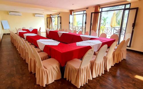 坎帕拉Kaazi Beach Resort的一排桌椅,上面有红白的桌布