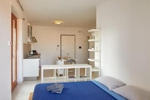 西维尔诺瓦·马尔凯Moderno Monolocale in Città con Parcheggio privato的一间带蓝色床的卧室和一间厨房