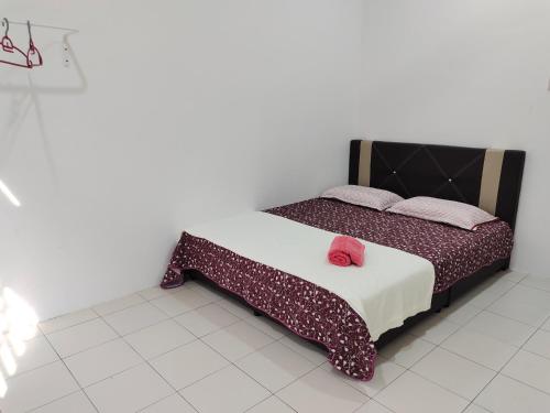 关丹FS Homestay Cherating的一间卧室配有一张带红色枕头的床