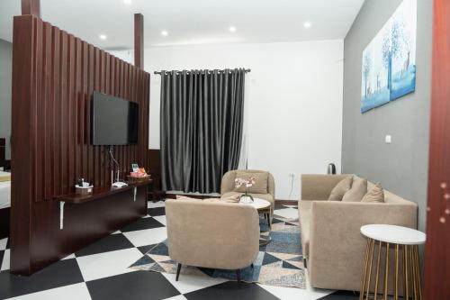 Tuyên QuangAnh Anh Luxury Hotel的客厅配有两把椅子和电视