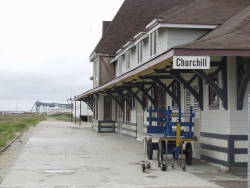 丘吉尔熊之乡旅馆的前面的火车站设有蓝色椅子