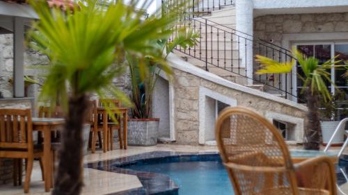 阿拉恰特Avlu Alaçatı Boutique Hotel的一个带桌椅的庭院和一个游泳池