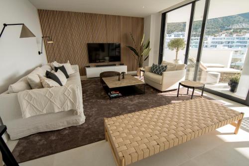 福恩吉罗拉Mara's Apartments Higueron West - Scandinavian Luxury - Views of the Sea and Natural Landscapes的客厅配有2张白色沙发和电视