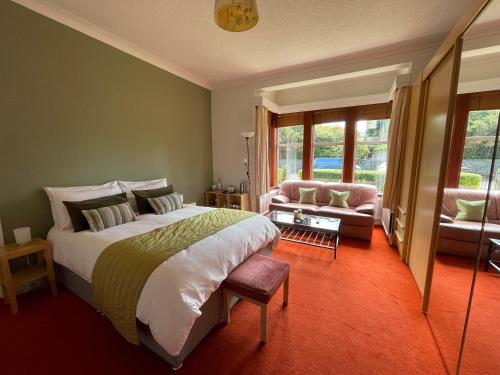 艾尔布莱克别墅住宿加早餐旅馆的一间卧室配有一张床、一张沙发和窗户。
