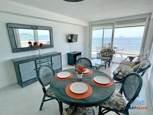 拉皮内达APARTBEACH BELL RACO ESQUINERO y FRENTE PLAYA的客厅配有桌椅,享有海景。