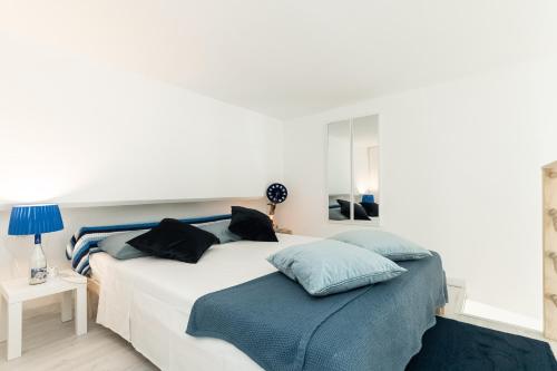 热那亚Sea Loft Quinto - A due passi dal mare的一间卧室配有白色床和蓝色枕头