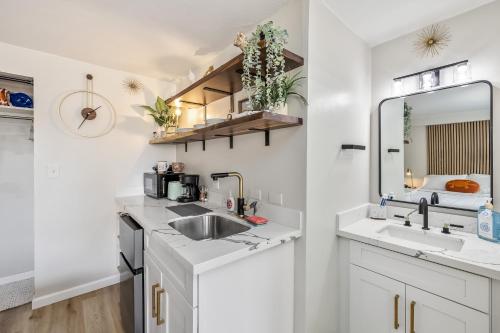 檀香山Bright & Cozy Condo Unit with Balcony!的白色的厨房配有水槽和镜子