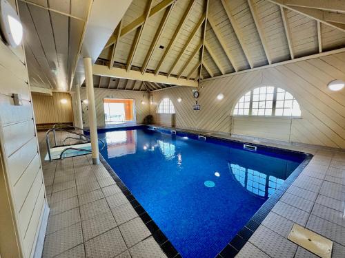 格伦科Holly Tree Hotel, Swimming Pool & Hot Tub的大楼内一个蓝色的大型游泳池