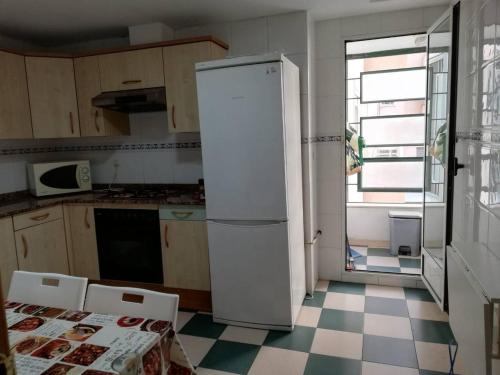 布尔哈索特PISO 4 HABITACIONES BURJASOT的厨房里设有白色冰箱,铺有 ⁇ 格地板