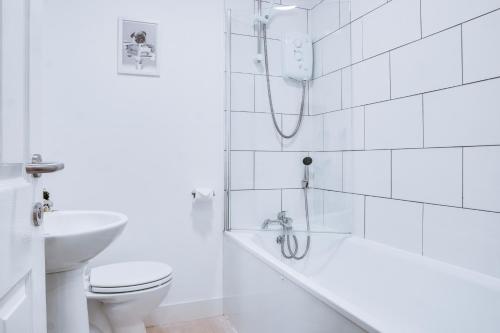 伯肯黑德Birkenhead - 2 bedroom house的白色的浴室设有浴缸和卫生间。