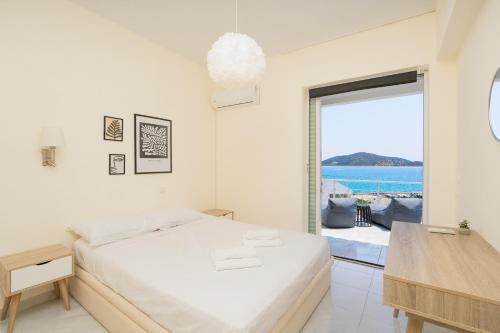 拉夫蒂港Phos Apartment by A&D Properties的一间白色的卧室,配有一张床,享有海景