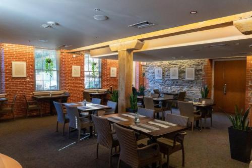 兰开斯特兰开斯特艺术酒店 的餐厅设有桌椅和砖墙