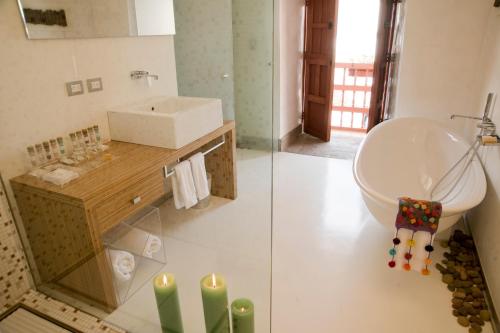 库斯科卡萨卡塔赫纳精品酒店及水疗中心的浴室的两张照片,配有水槽和浴缸