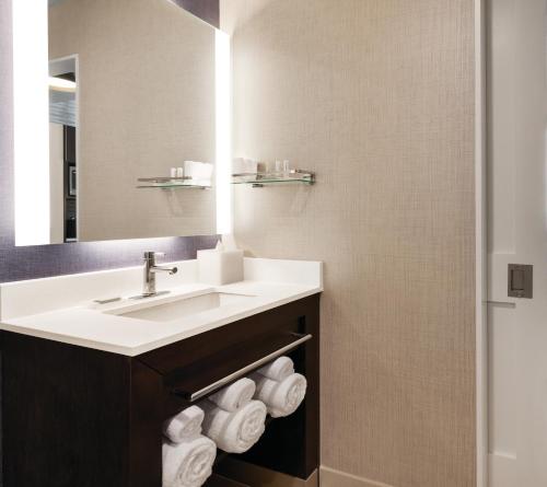 皇后区Residence Inn by Marriott New York JFK Airport的浴室配有盥洗盆、镜子和毛巾